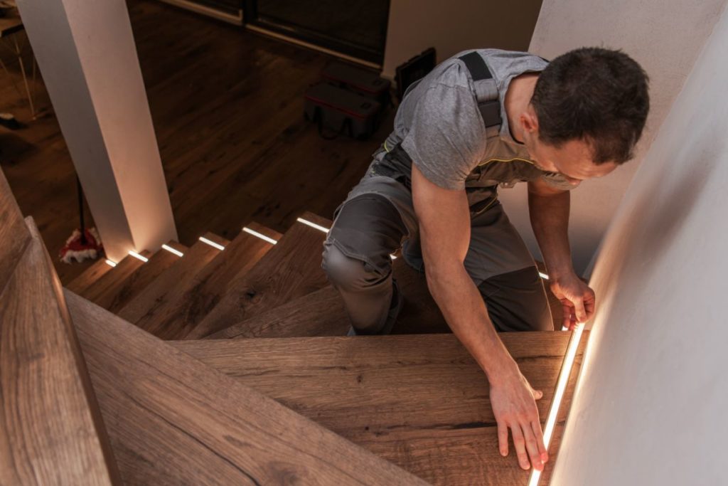 Worker installing home stairs modern illumination